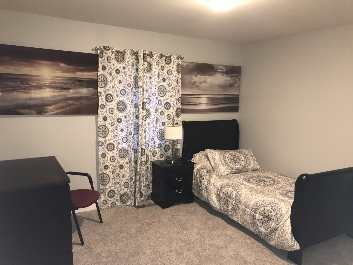 A cozy bedroom with a single bed and patterned decor.