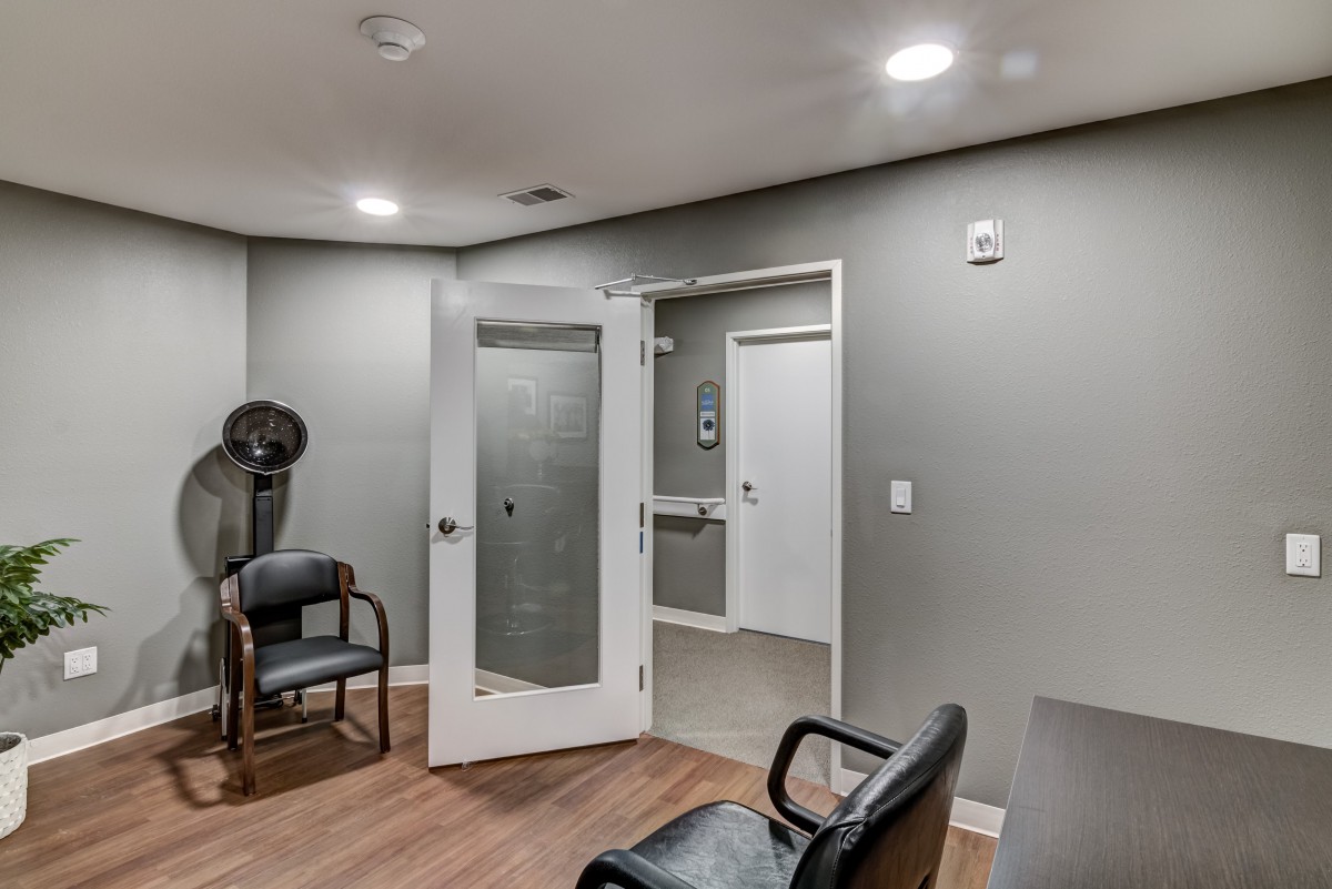 A modern waiting area with seating and a glass-panel door.