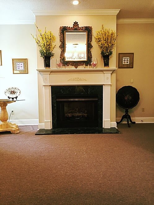 A cozy living room with a classic fireplace and decorative elements.