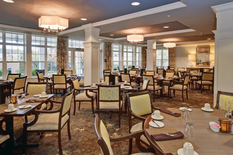 A spacious and elegantly decorated dining room with neatly arranged tables and chairs.
