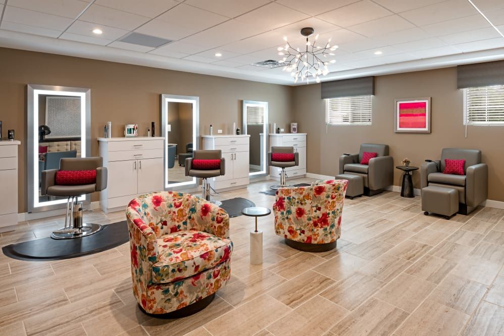 A chic and modern salon interior with floral chairs and elegant lighting.