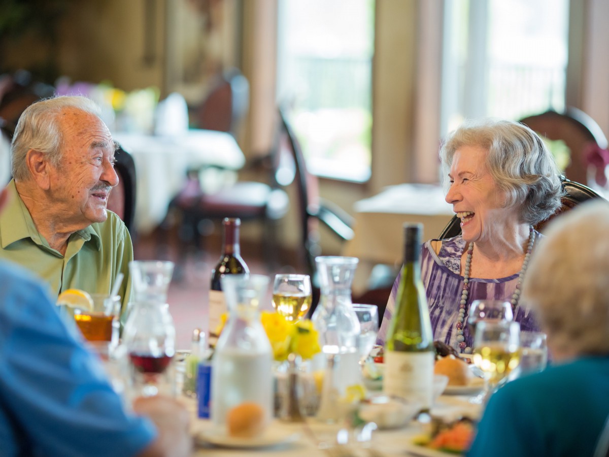 Elderly group happily dining together at a restaurant.