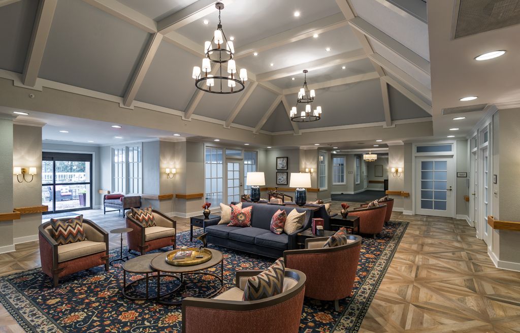 A spacious and elegantly designed living room with comfortable seating, decorative chandeliers, and a warm ambiance.