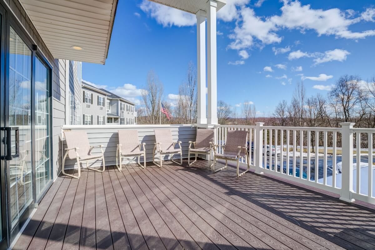 A spacious outdoor deck with seating and railings under a clear blue sky.