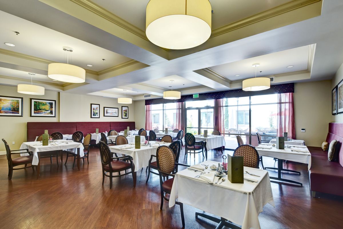 A spacious and elegantly designed restaurant interior with neatly arranged tables and chairs.