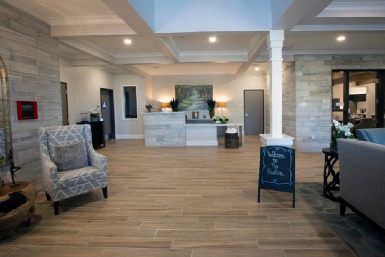 A modern reception area with stylish furniture and wood flooring.
