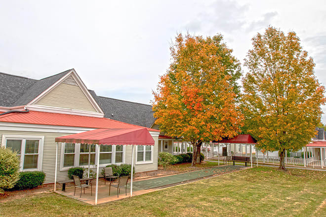 A house with a patio and trees displaying autumn colors.