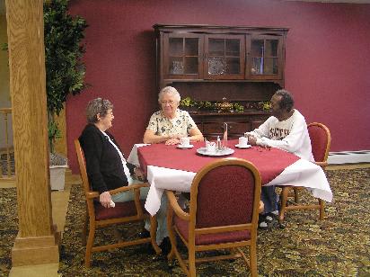 Three people sitting around a table having a conversation.