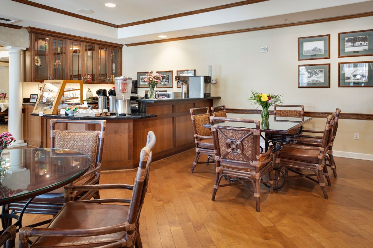 A cozy cafe seating area with wooden furniture and a coffee station.