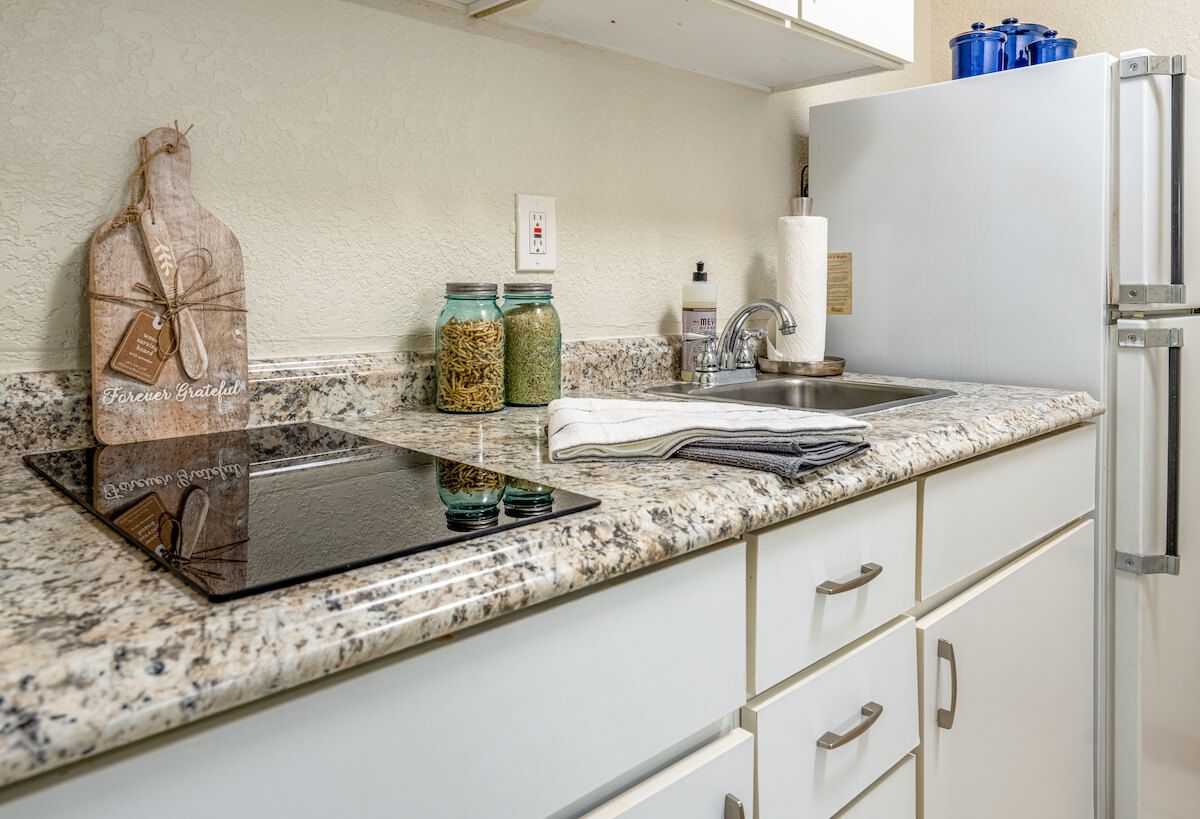 Modern kitchen featuring a stovetop, sink, and granite countertops.