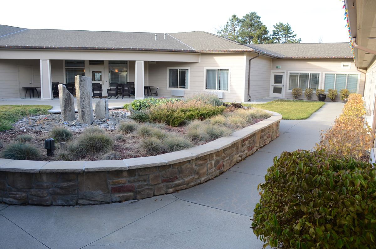 A view of a modern building with a landscaped courtyard and garden.