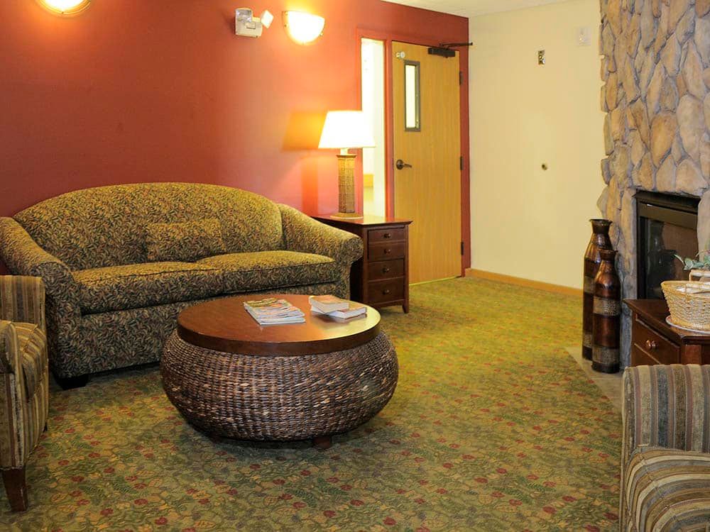 A cozy living room with a patterned sofa, a round table, and warm lighting.