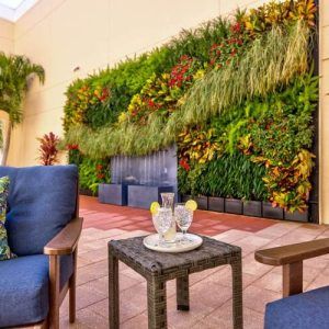 A cozy outdoor patio with comfortable seating and a lush vertical garden.