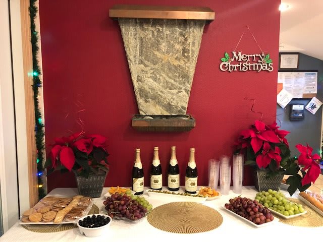 A festive Christmas setup with wine, grapes, and poinsettias.