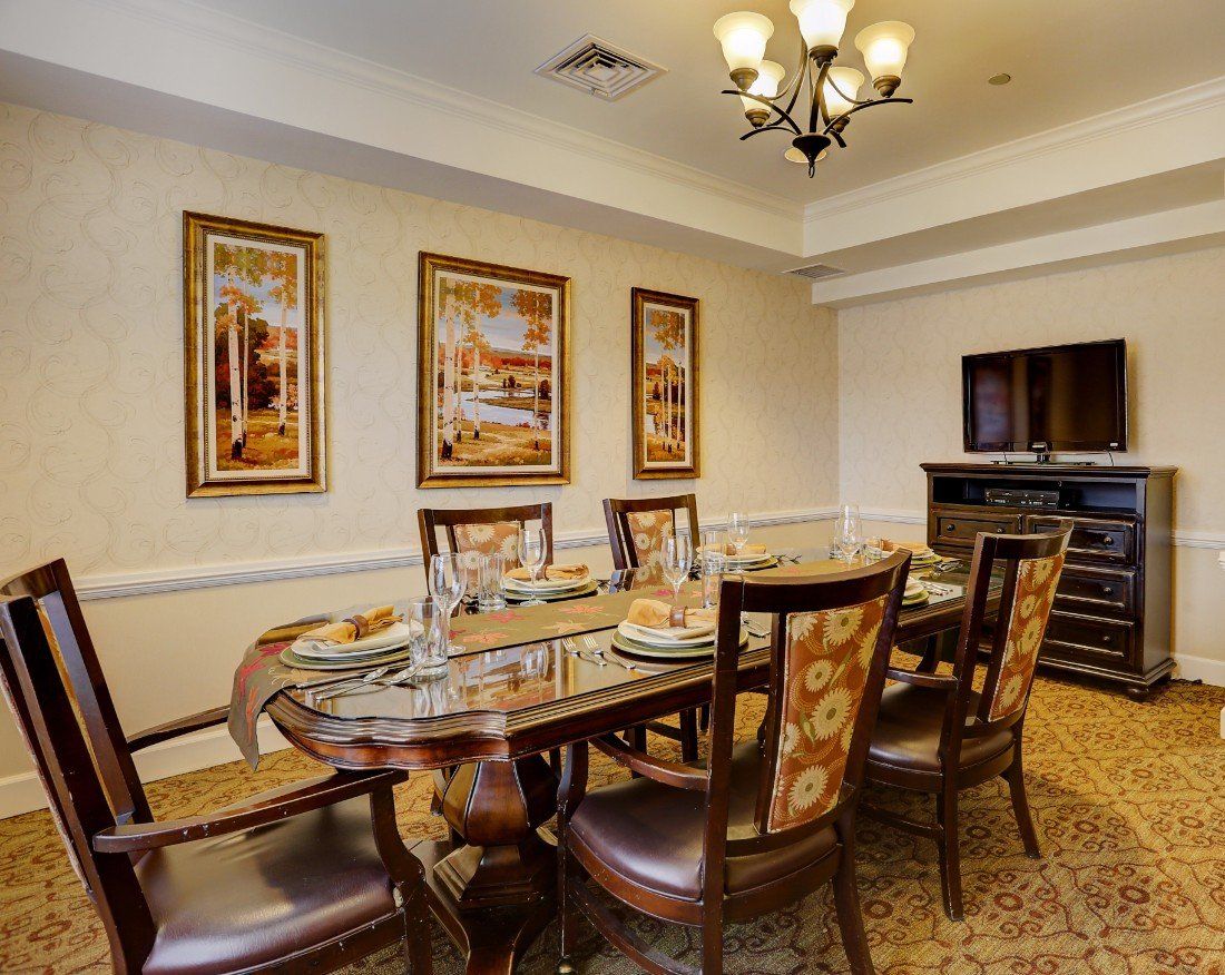 An elegant dining room with a large table, chairs, and wall art.