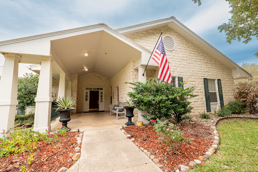 Inviting entrance to a charming home with beautiful landscaping and an American flag.
