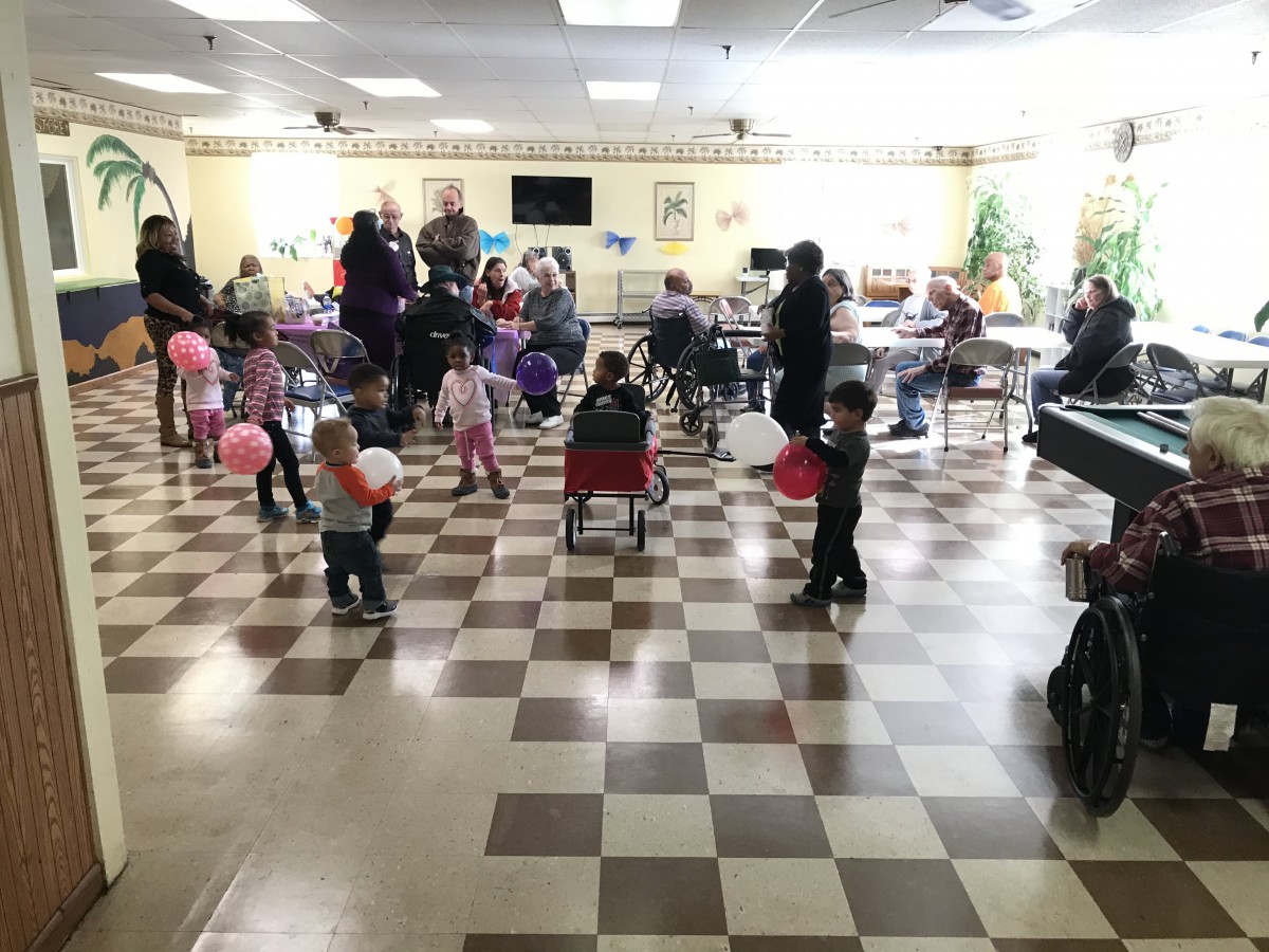 Children playing with balloons at an indoor community event.