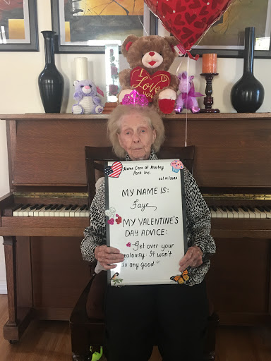 A joyful elderly person celebrating a special occasion with a festive sign at the piano.