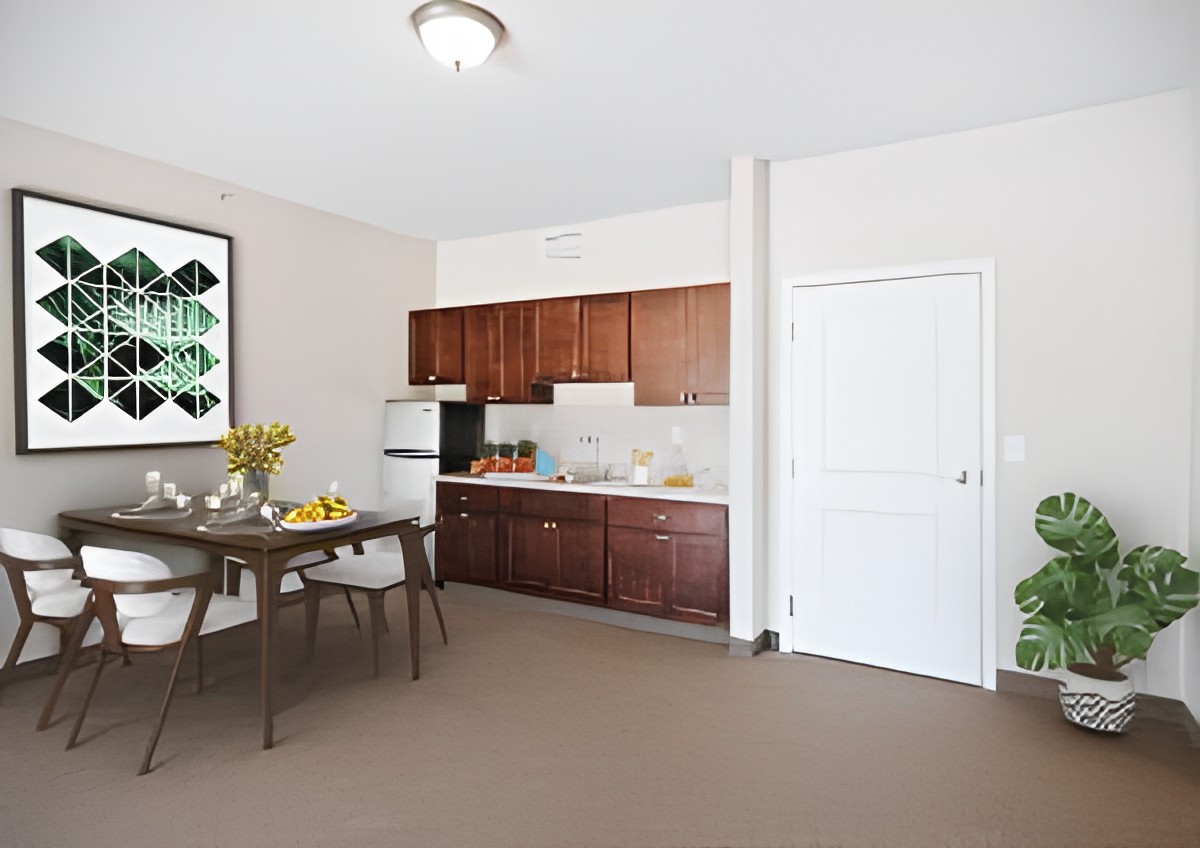 A modern kitchen with wooden cabinets, dining table, and chairs.