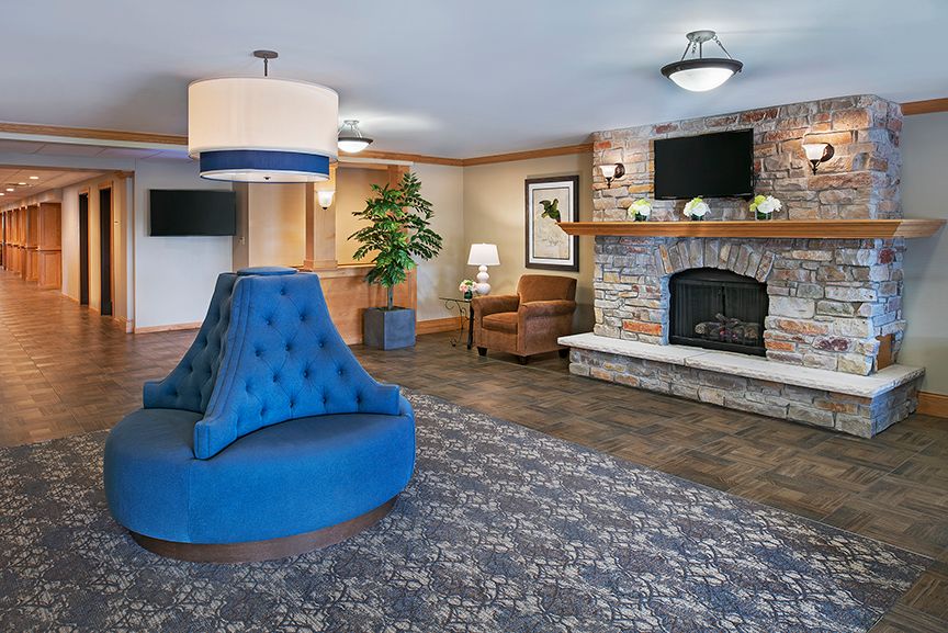 A modern hotel lobby featuring a cozy fireplace, elegant seating, and stylish decor.