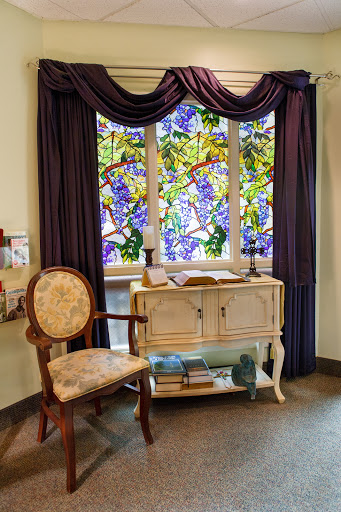 A beautifully designed corner featuring a stained glass window and elegant furniture.