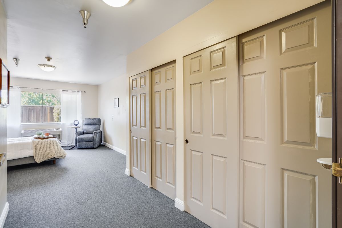 A modern bedroom interior with multiple closets and a carpeted floor.