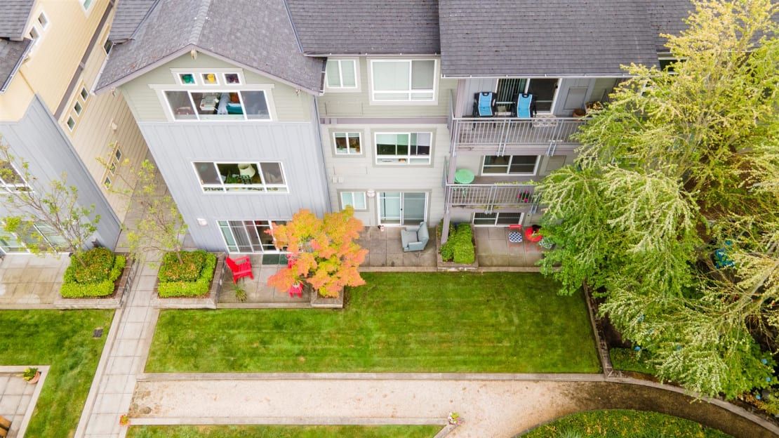 Aerial view of a residential apartment building with balconies and well-maintained lawns.