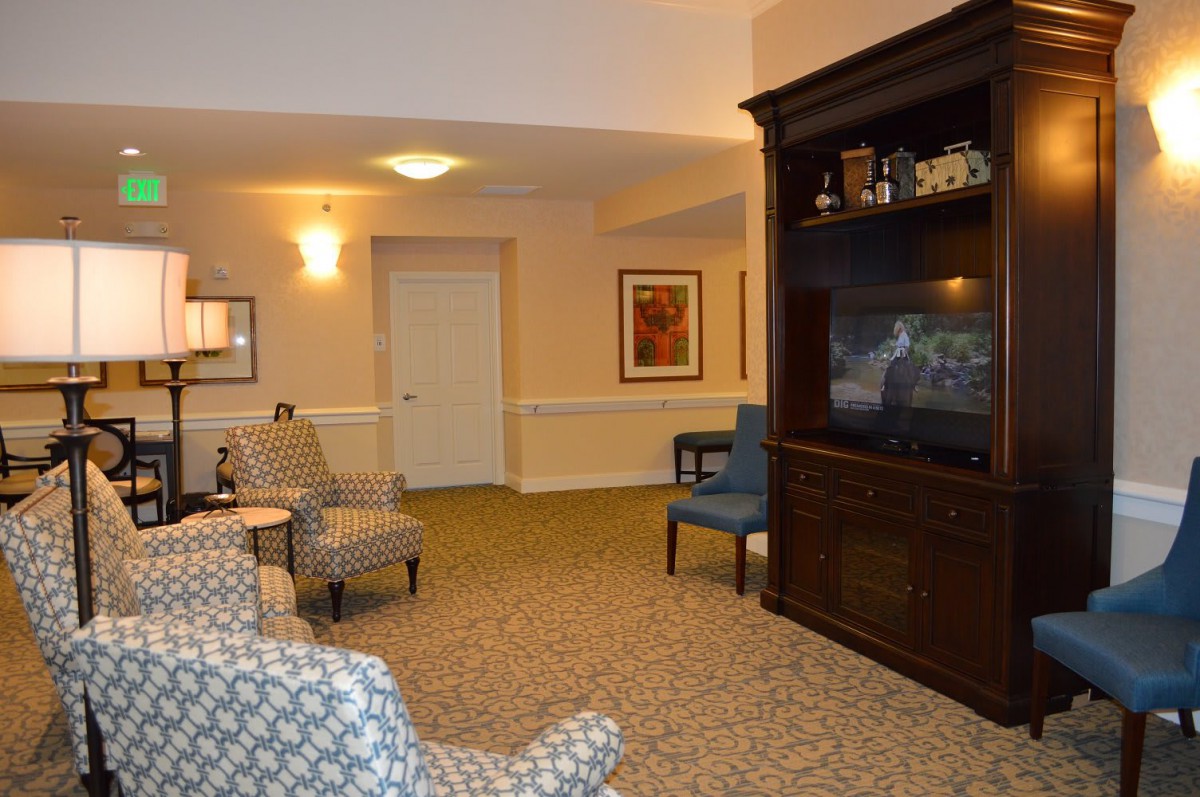 A cozy living room featuring comfortable chairs, a large television, and elegant interior decor.