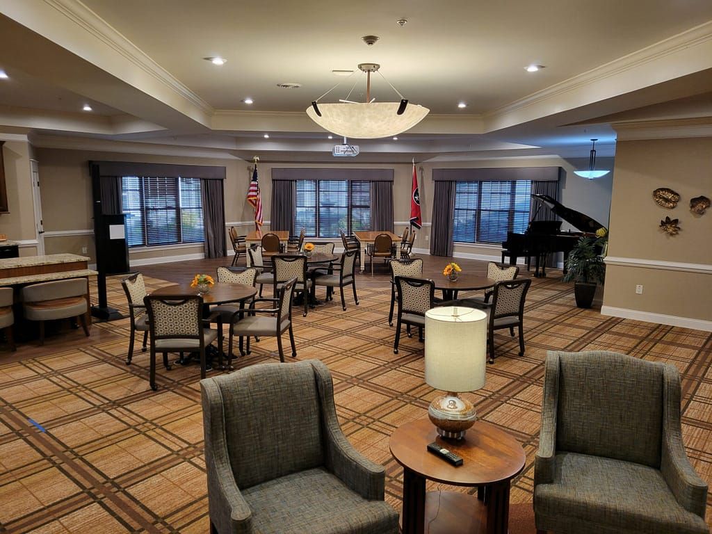 A spacious lounge area featuring a grand piano, comfortable seating, and elegant lighting.