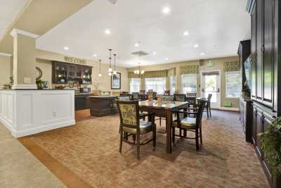 A spacious open-concept dining and kitchen area with elegant furnishings and ample lighting.