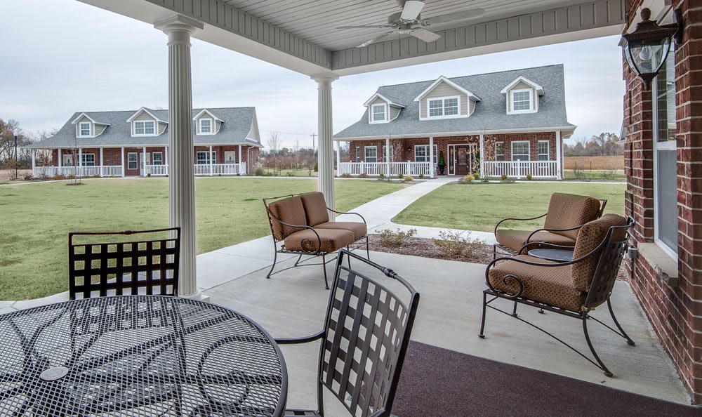 A cozy outdoor patio with comfortable seating and a view of charming houses.