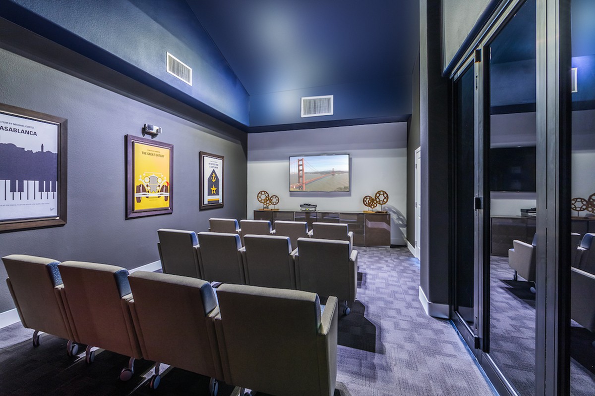 A modern home theater with rows of comfortable seating and a large screen.
