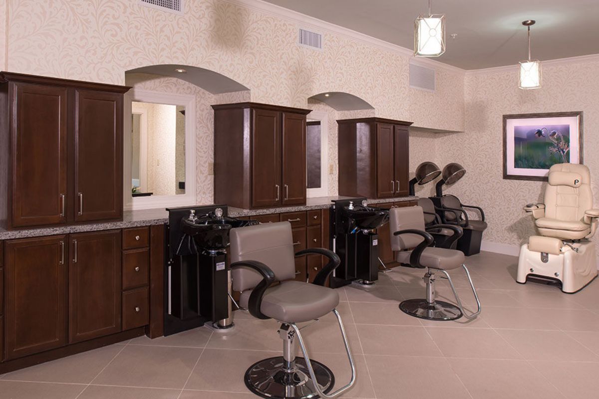 An empty hair salon featuring styling chairs and mirrors.