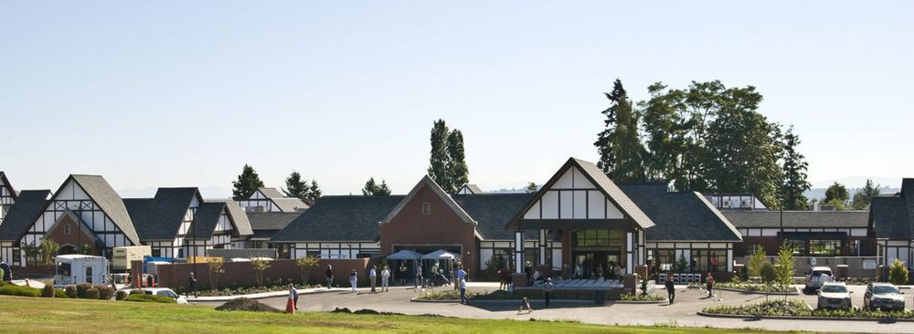 A spacious outdoor area with people gathered near a building, showcasing traditional architecture.