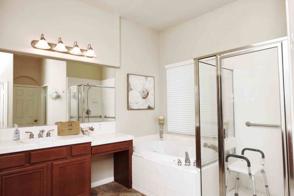 A modern bathroom featuring a bathtub, shower enclosure, and vanity with mirror.