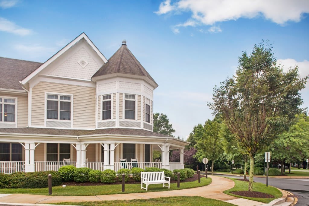 A charming Victorian-style house with a wraparound porch and landscaped garden.