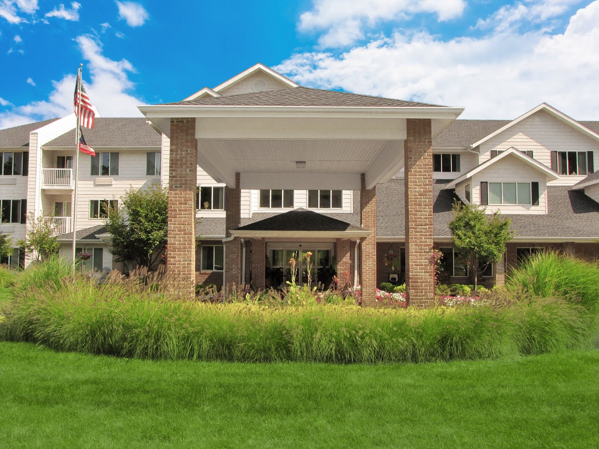 A modern building with a landscaped lawn and a blue sky background.