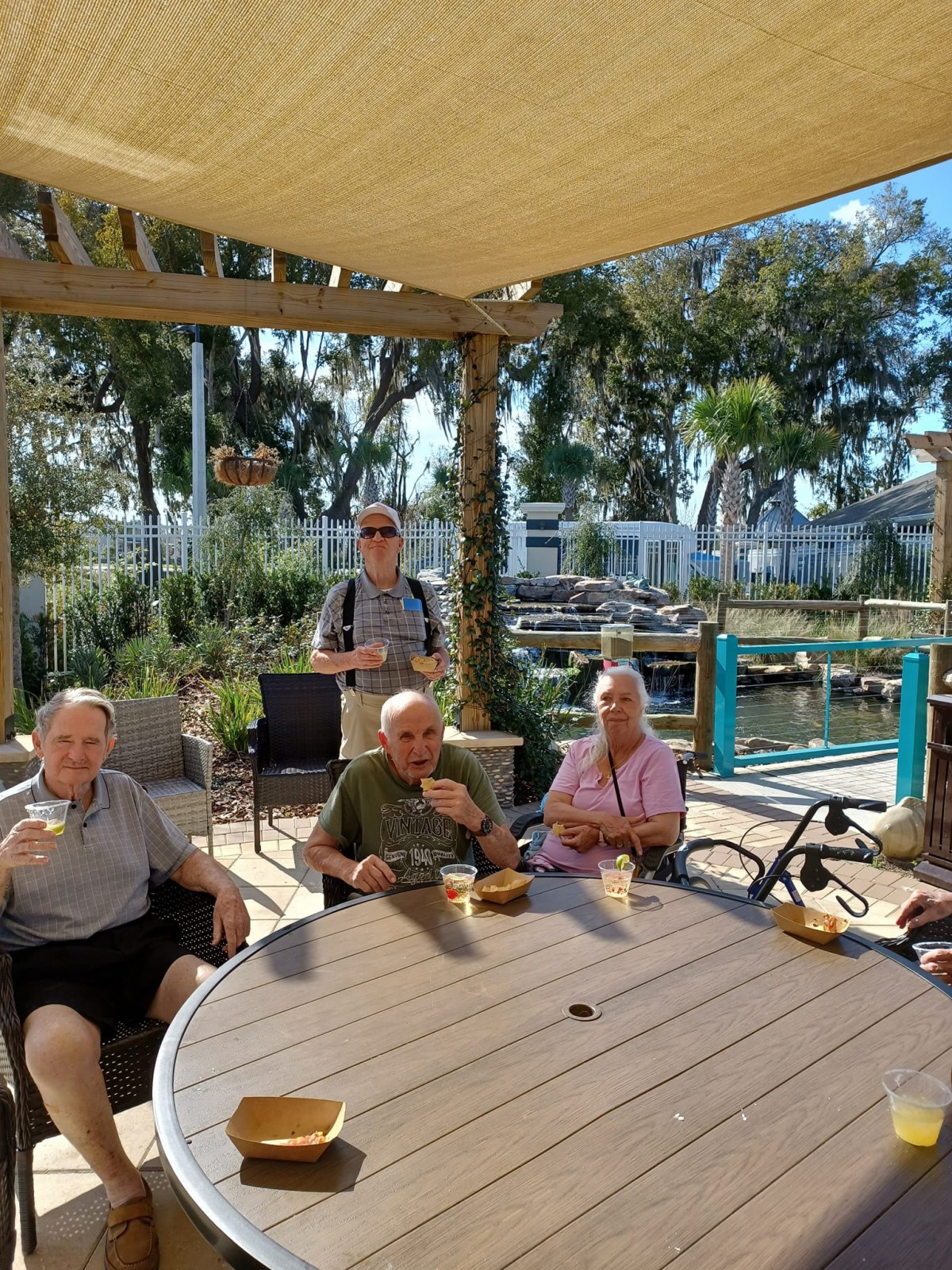 A group of people enjoying a relaxed gathering on a sunny outdoor patio.
