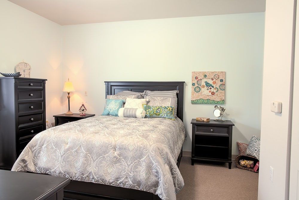 A cozy bedroom with a neatly made bed, nightstands, and decorative items.