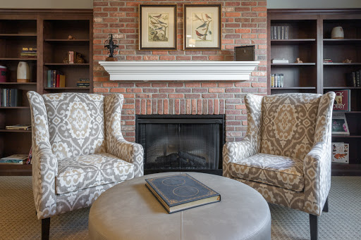 A cozy living room featuring a brick fireplace and stylish armchairs, perfect for relaxation.