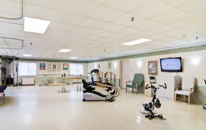 A spacious indoor gym area featuring various exercise equipment, including a treadmill and stationary bike.