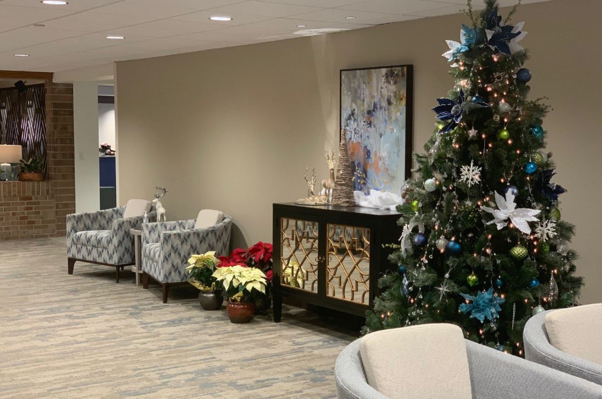 A cozy office waiting area adorned with a decorated Christmas tree and holiday dcor.