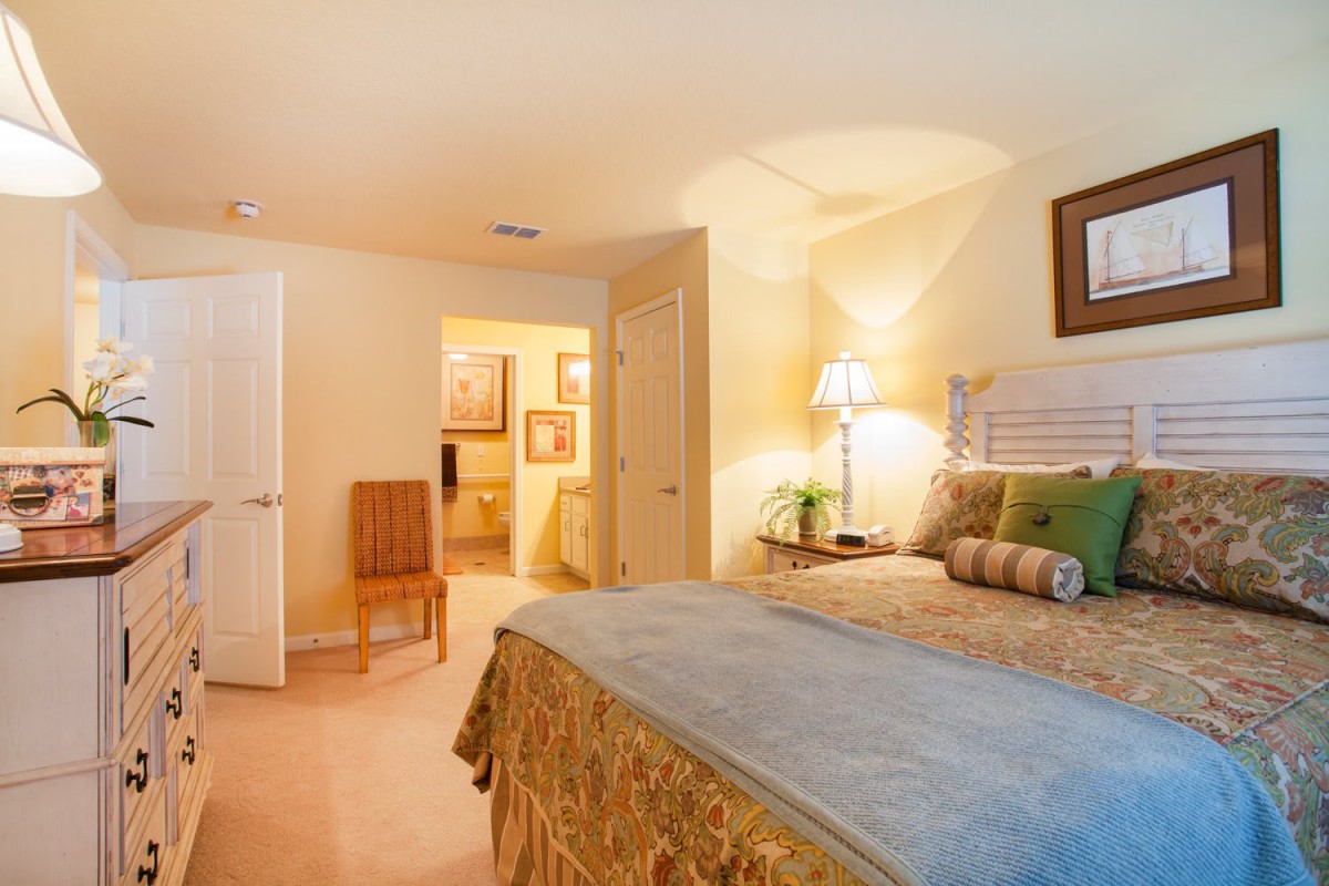 A cozy bedroom with a neatly made bed and soft lighting.