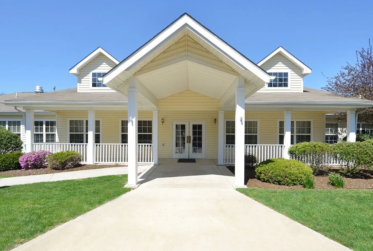 A beautiful suburban house with a large porch and well-maintained garden.