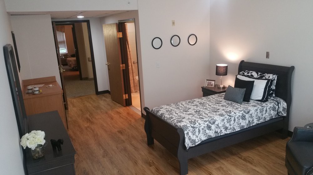 A minimalist bedroom with wood flooring and a single bed.