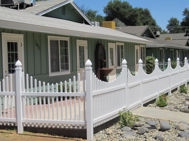 A residential house with a white picket fence and a small patio area.