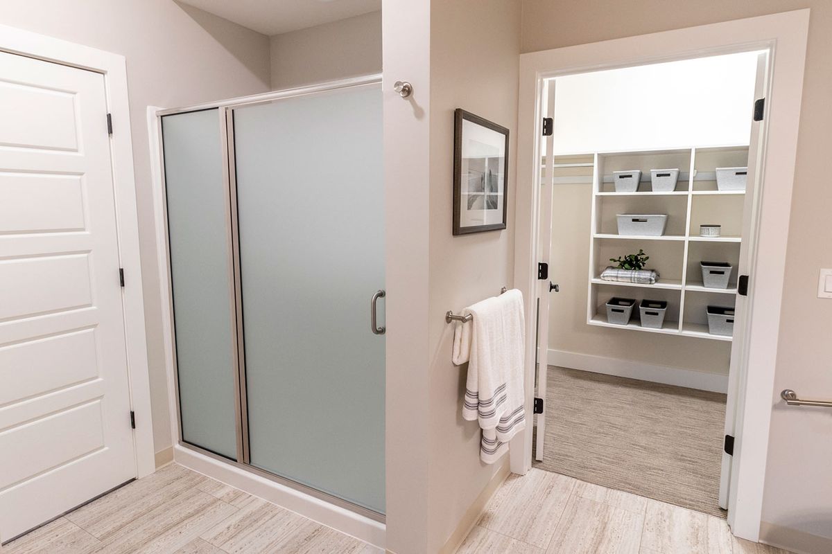 A modern bathroom featuring a glass-door shower and neatly hung towels.