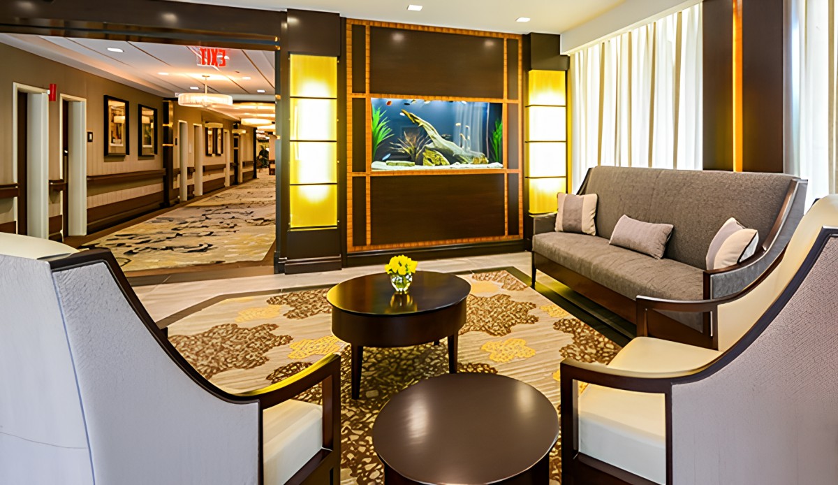 A modern hotel lobby with stylish seating and an aquarium display.