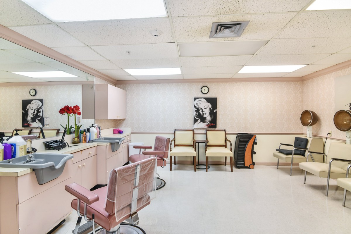A modern beauty salon with pink chairs, mirrors, and a stylish interior.