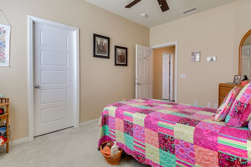 A cozy bedroom with a colorful quilt and simple decor.